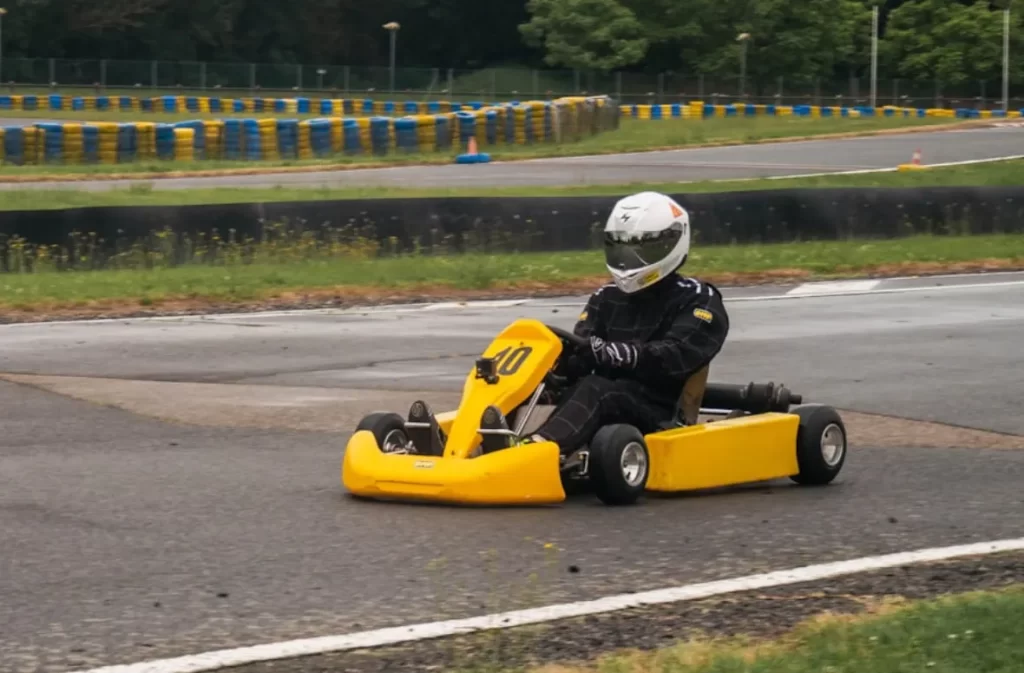 Go-kart driver navigating a curve at the indoor track.
