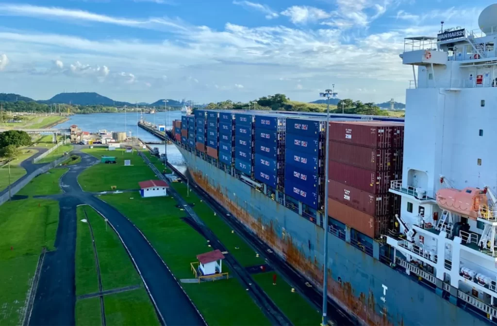 Cargo trailers on a large freight ship in a canal.