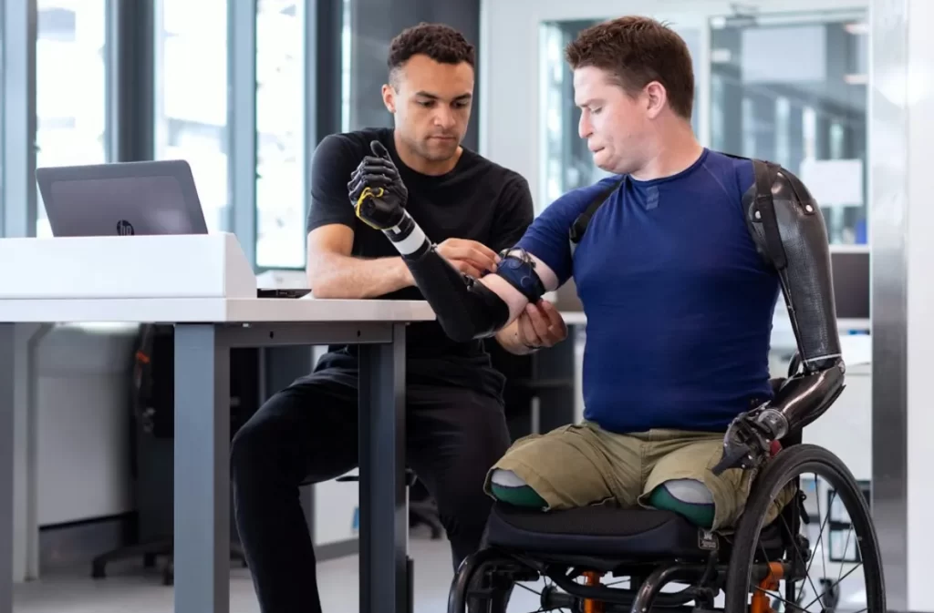 Man with prosthetic arms in a disability support session.