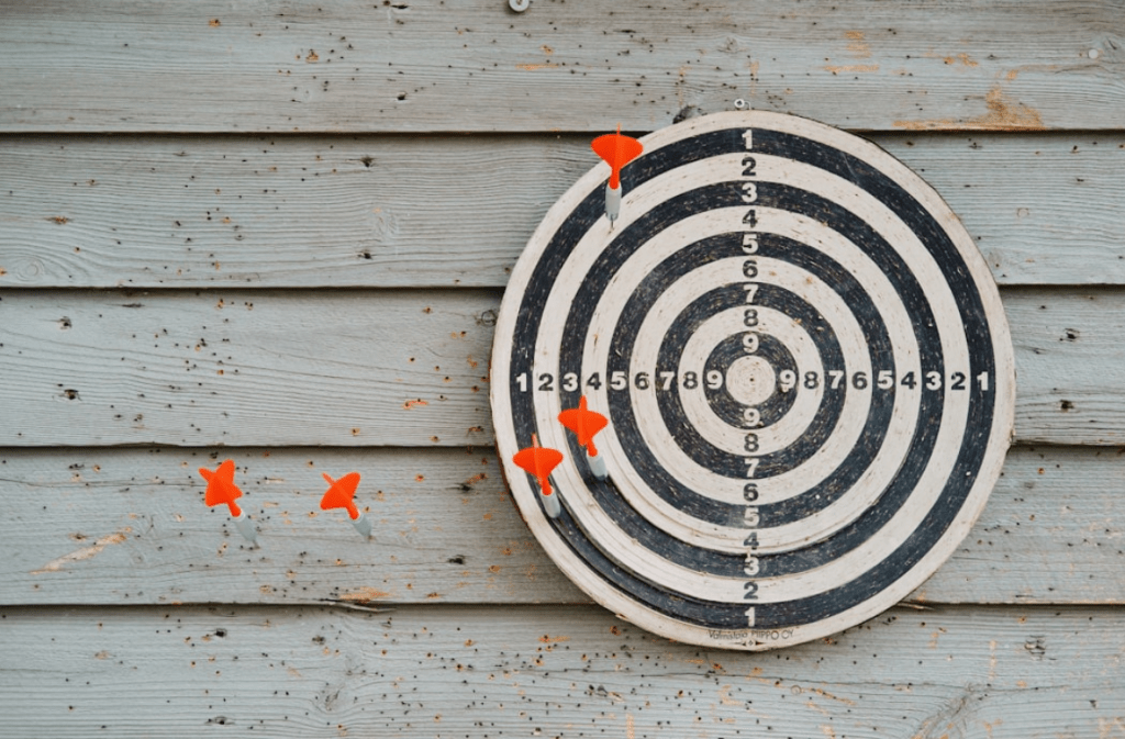 Dartboard with darts scattered on target.