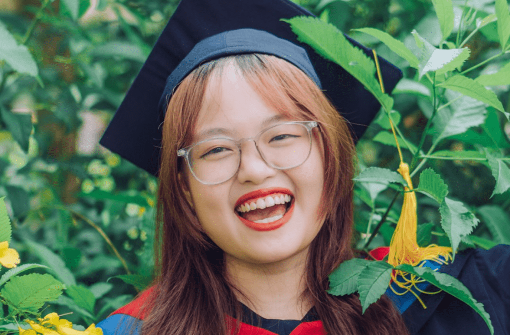 Happy psychology graduate in cap and gown.
