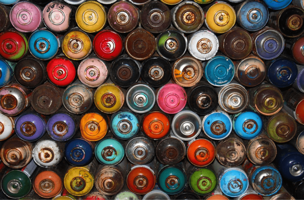 Collection of colorful spray cans, top view.