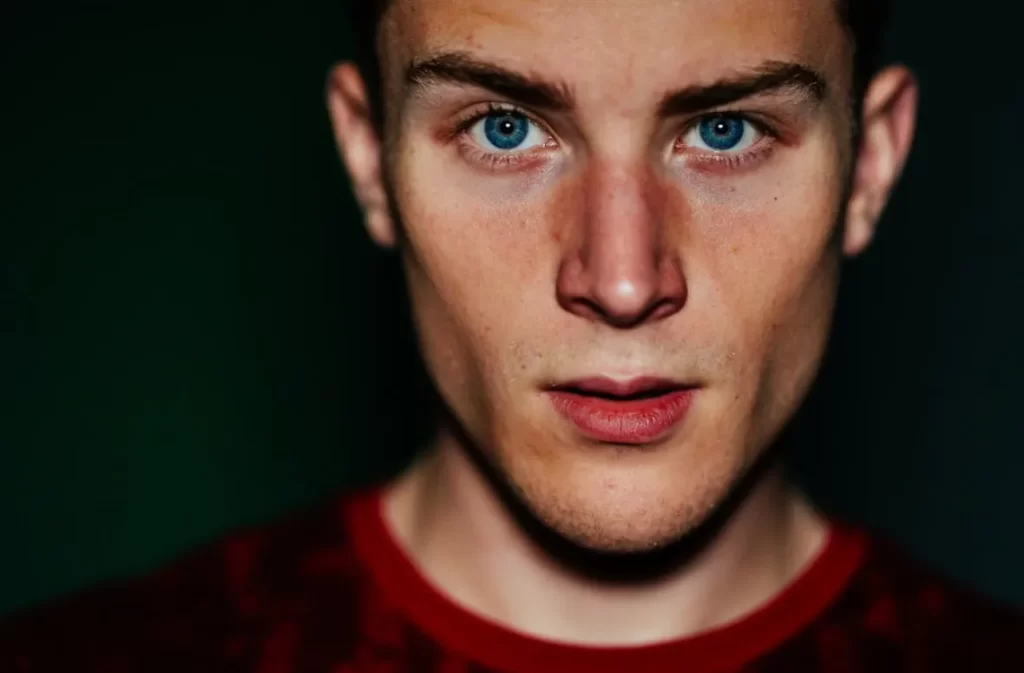 Man with piercing blue eyes in a close-up portrait.