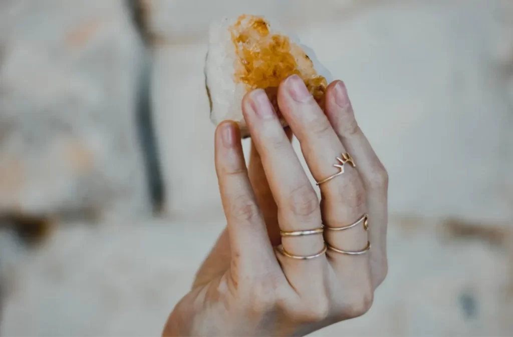 Crystal award held by a hand wearing rings.