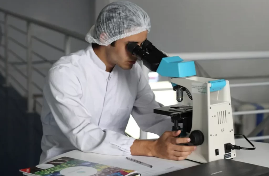 Intern examining a sample under a microscope.