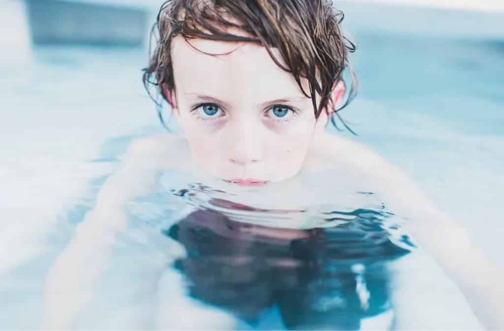 Boy with intense eyes staring from water.