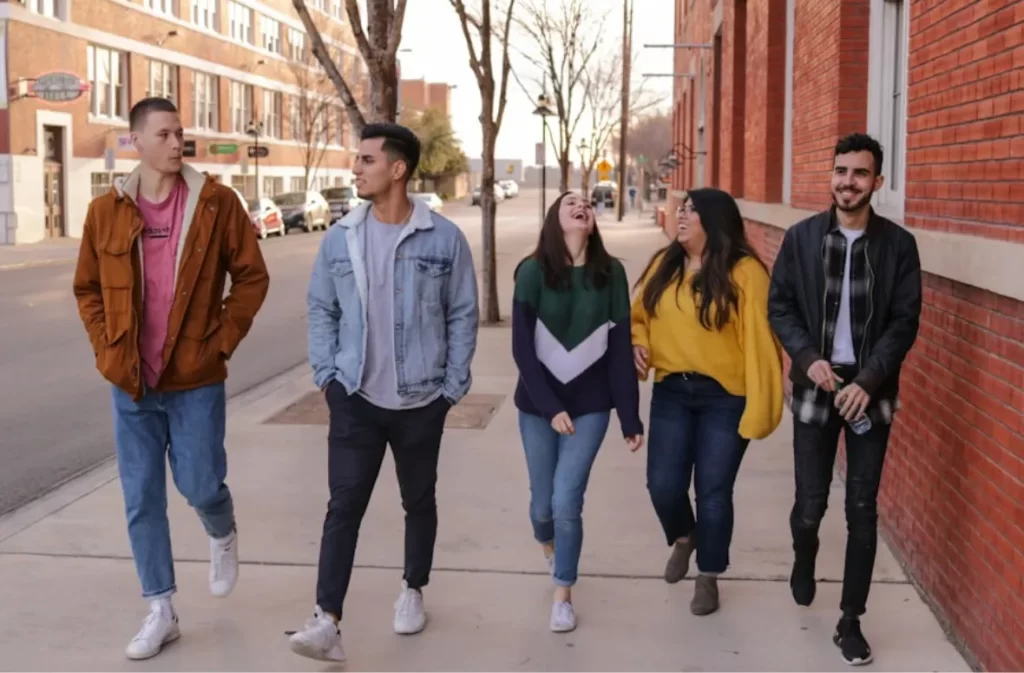 Youth walking together on a city sidewalk.
