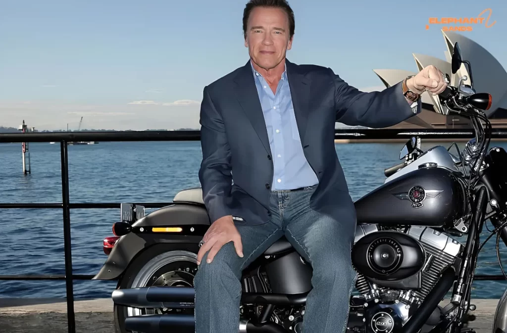 A man in a suit sitting on a Harley-Davidson by a waterfront.