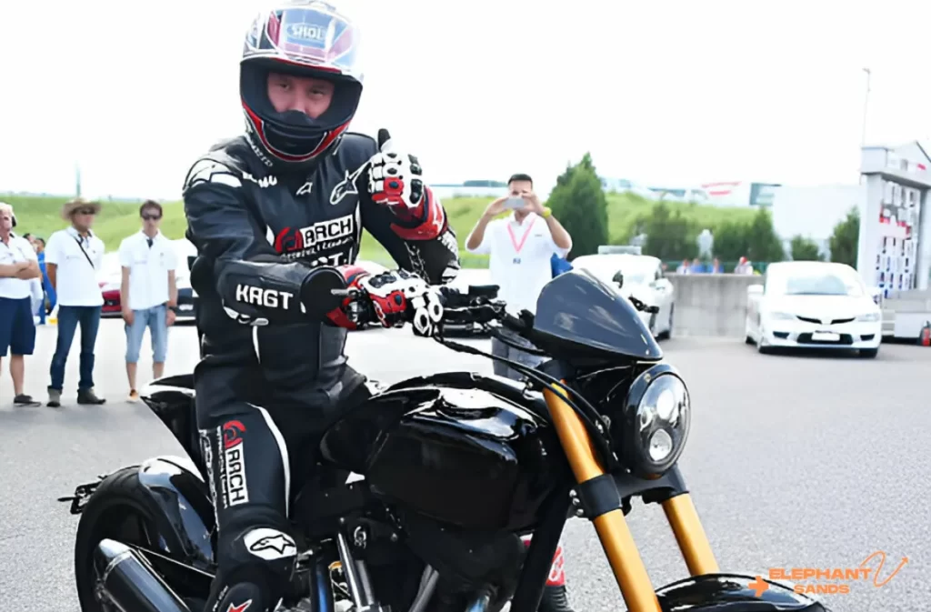 A racer in full gear riding a sporty Harley-Davidson bike.