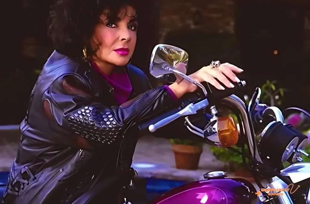 A woman in leather posing with a purple Harley-Davidson.