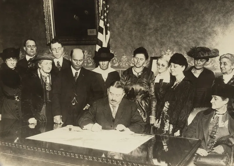 Group of individuals in a historical signing ceremony.