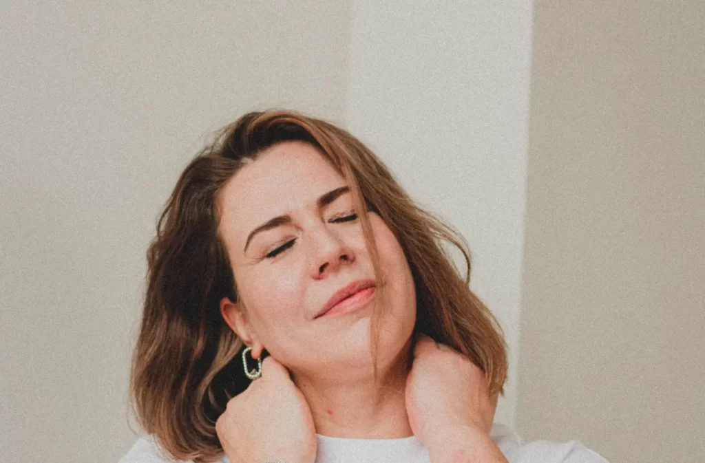 Woman relaxing while holding her neck gently.