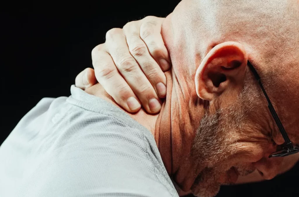 Older man massaging his neck for relief.