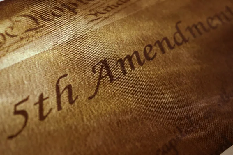 Highlighted text of the 5th Amendment on parchment.